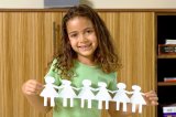 Portrait of Hispanic girl with paper doll